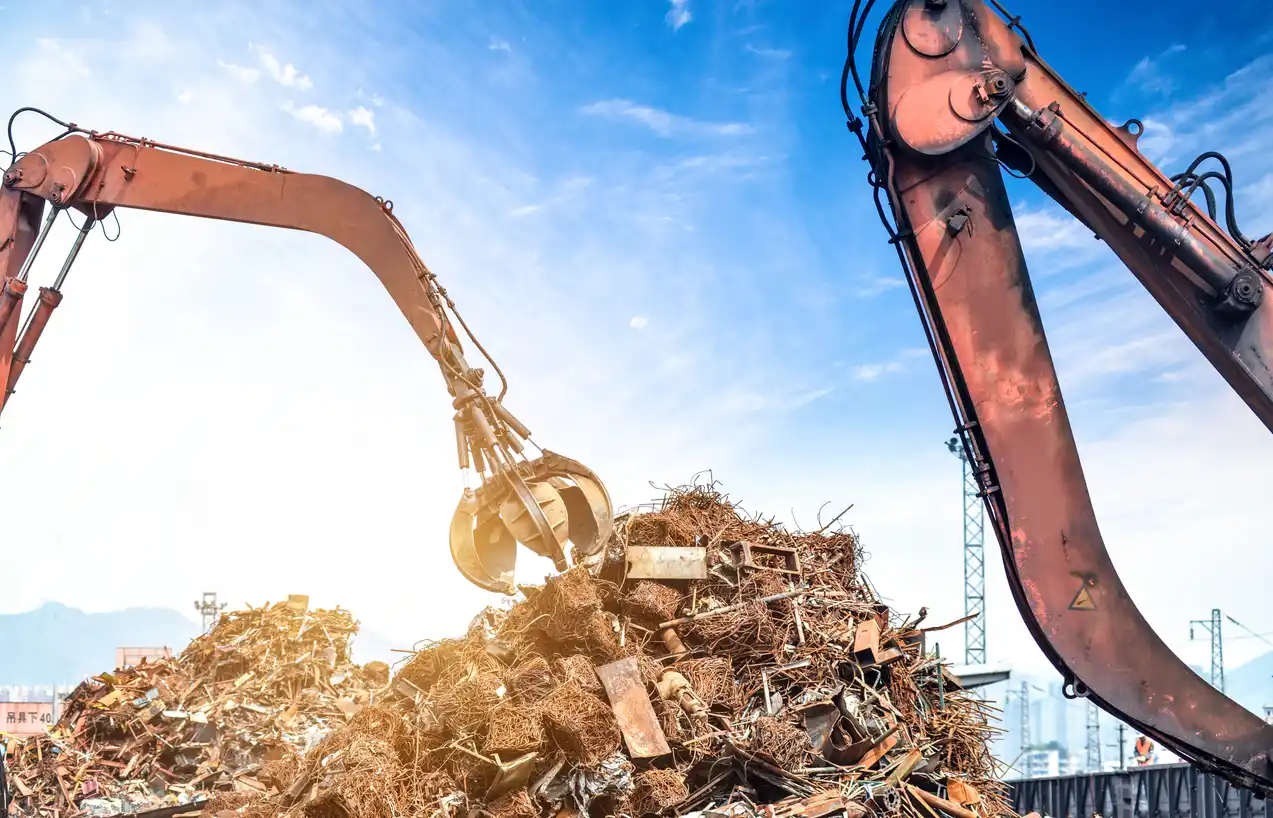 Industrial crane grabbing bulk scrap metal for recycling